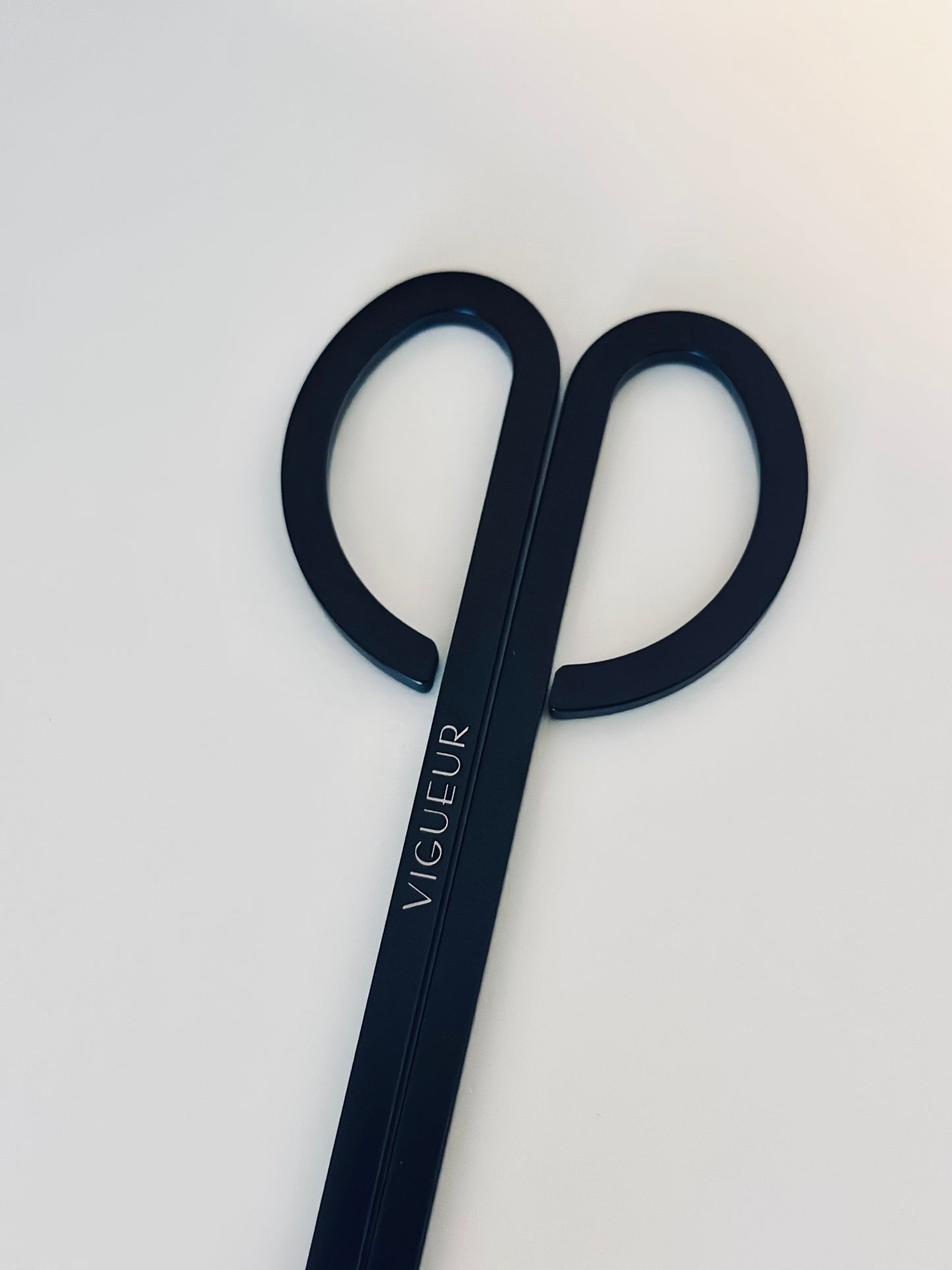 Black candle wick trimmer with 'Vigueur' branding 